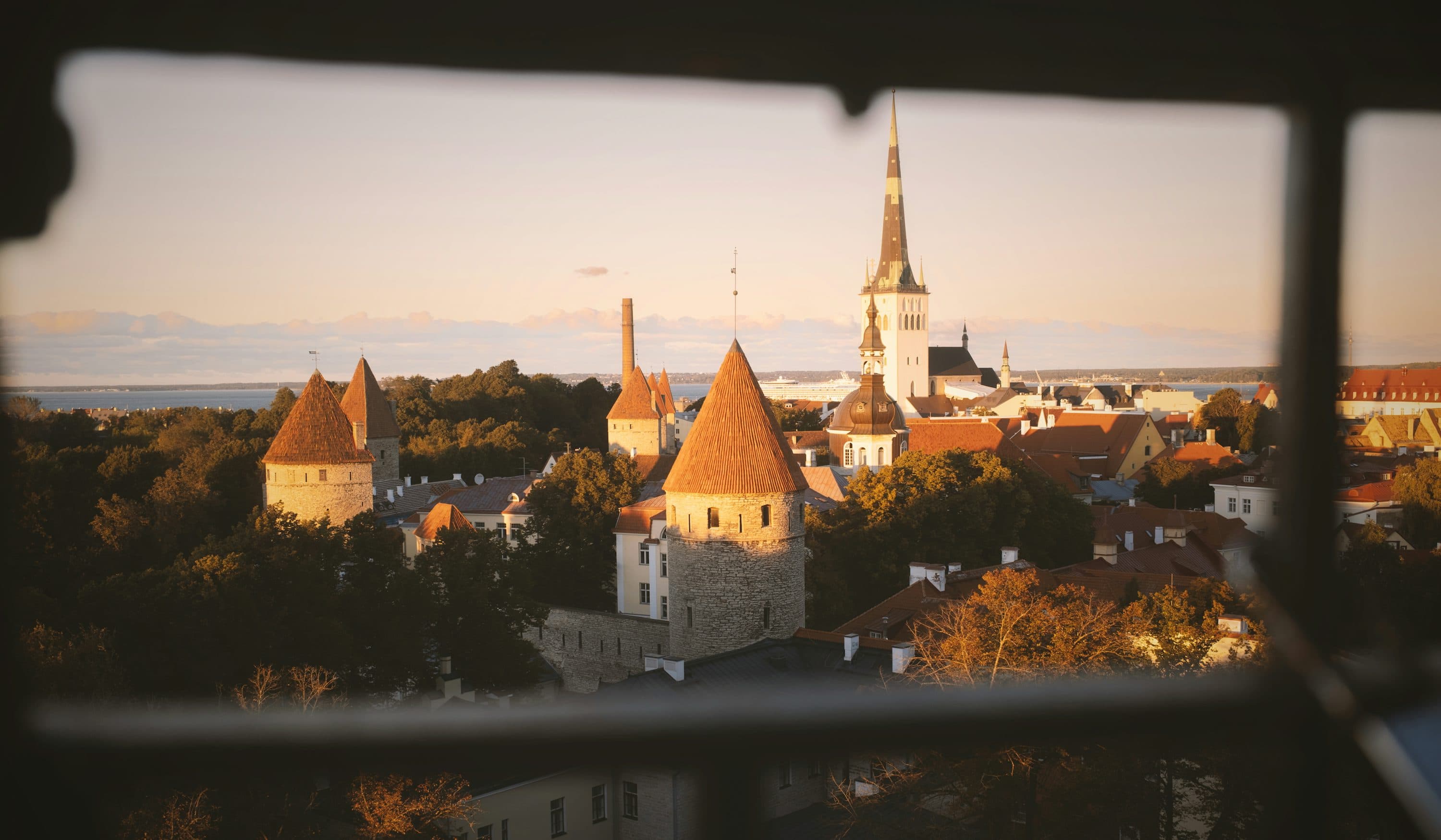 Gün batımında Tallinn’in tarihi kuleleri, çatıları ve şehir manzarası